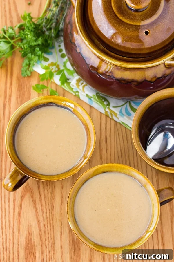 Two mugs filled with creamy French onion soup, ready to be served.
