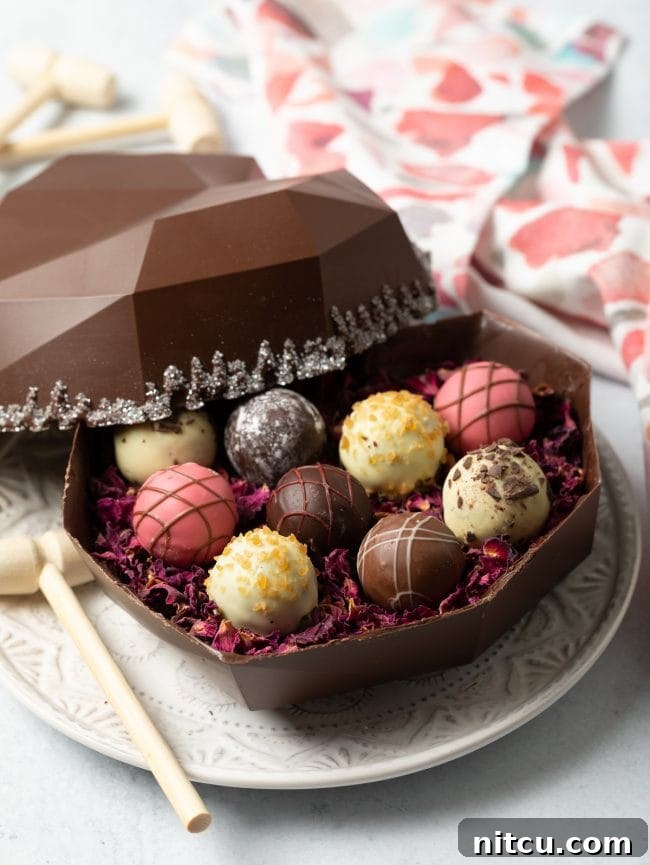Crackable Chocolate Treasure 11 A side view reveals an open bakery box containing a breakable chocolate heart shell, artfully filled with an enticing array of gourmet truffles.