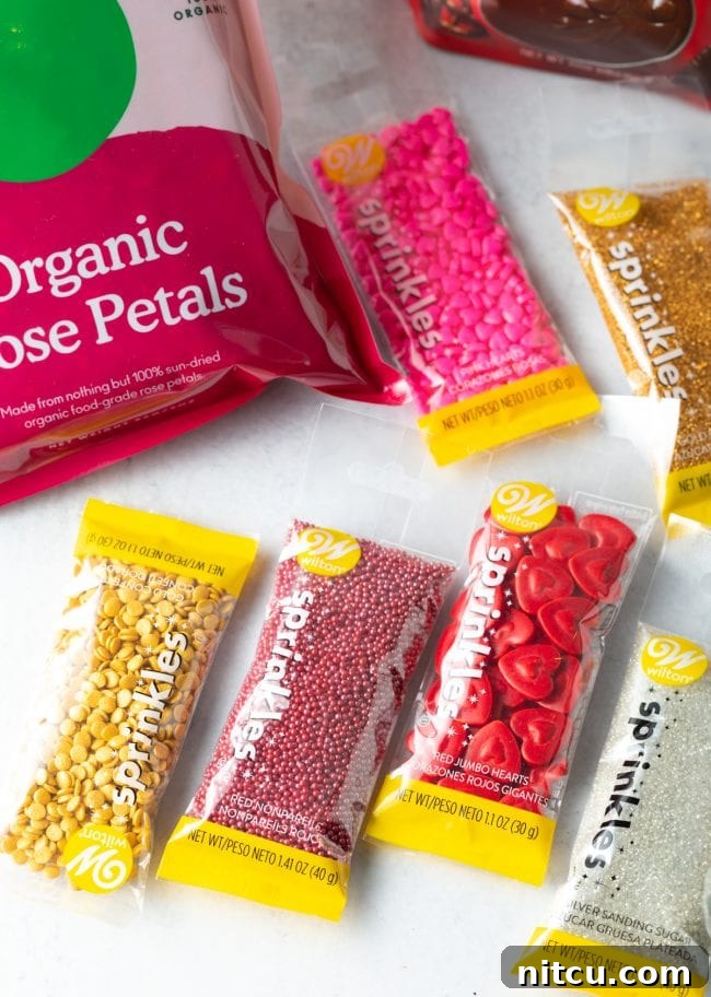 Crackable Chocolate Treasure 5 A vibrant assortment of colorful sprinkles in various shapes and textures are neatly arranged on a clean white surface, ready for creative decoration.
