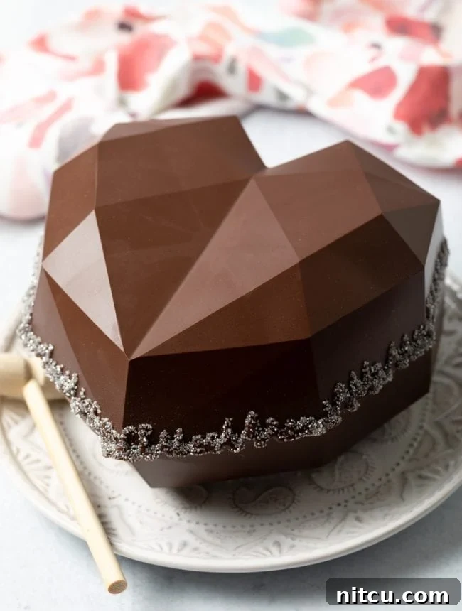 Crackable Chocolate Treasure 9 A dazzling, complete breakable chocolate heart gift box sits on a white surface, encircled by edible glitter, sparkling with festive charm.