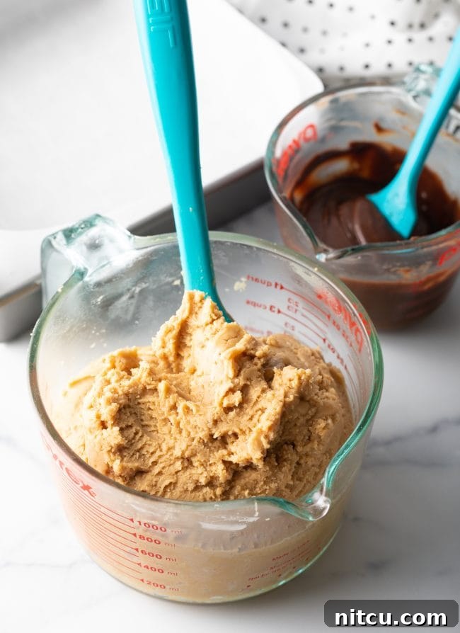 Peanut Butter Delights 9 The smoothly mixed fudge base in a large glass mixing cup with a blue spatula, showing its ready consistency.