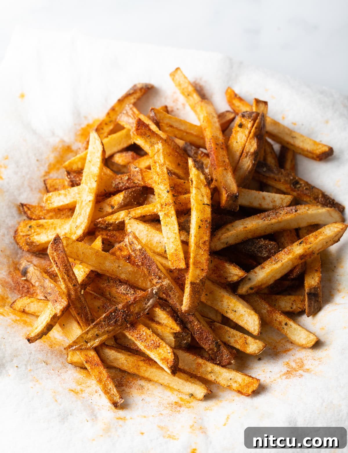 Cajun Fries: Homemade Seasoning Blend Recipe 11 Top view sliced cajun seasoned fries on a white towel.