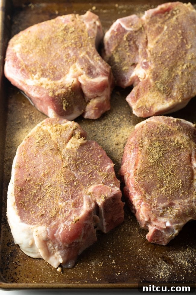 Seasoned pork chops on a tray. 