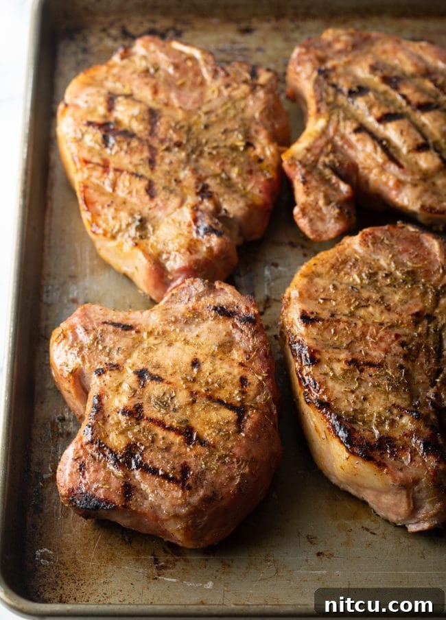 Cooked seasoned pork chops on a baking tray. 