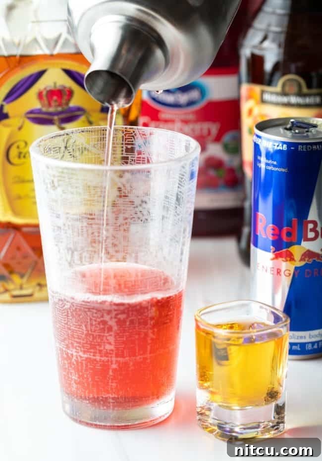 Sin City Slam 6 Shaker pouring Vegas bomb shot base into a tall glass with a shot of red bull on the side.