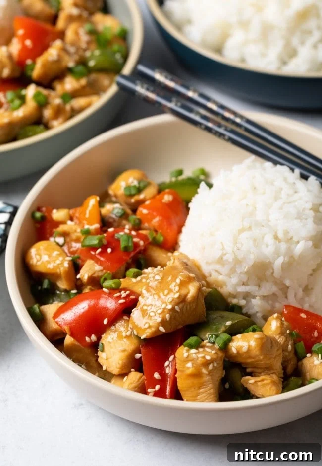 Top view bowl of Chinese garlic chicken with bell peppers with scoop of white rice.