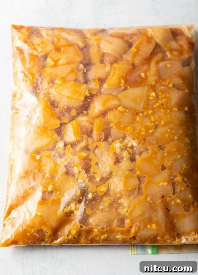Top view plastic ziploc bag with marinating chicken pieces.