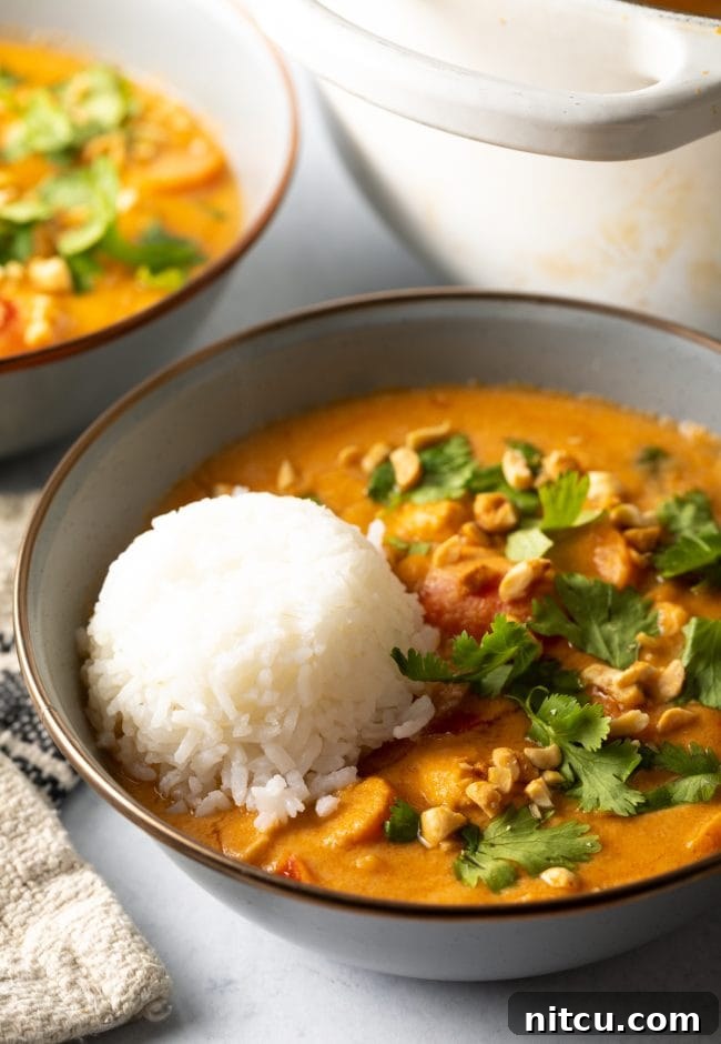 Authentic West African Maafe Peanut Stew 13 Close up of plated Maafe in a bowl with a serving of rice, showing the creamy texture and vibrant ingredients.
