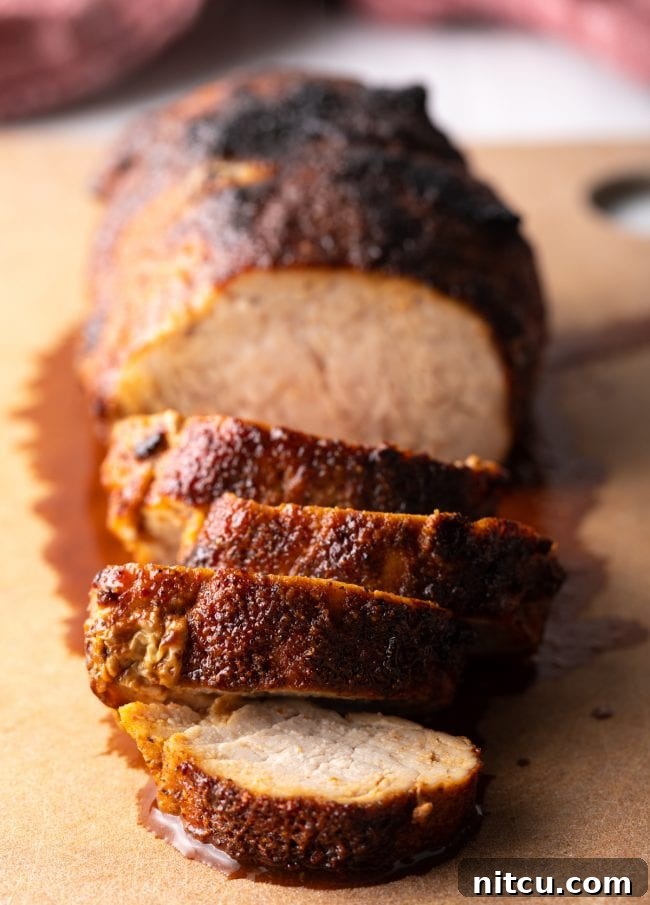 Slices of golden brown, air-fried pork tenderloin beautifully arranged on a rustic cutting board.