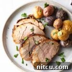 A perfectly cooked, spice-rubbed pork tenderloin, expertly sliced and ready to be served on a platter.