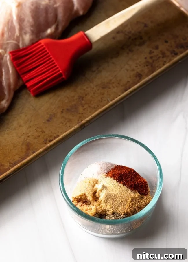 A small glass bowl filled with the vibrant spice rub ingredients, showcasing the mixture before application to the pork.
