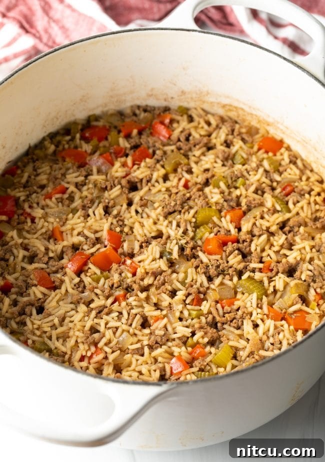 Soulful Cajun Dirty Rice 8 Cooked ground beef and vegetables mixed with rice in a pot.