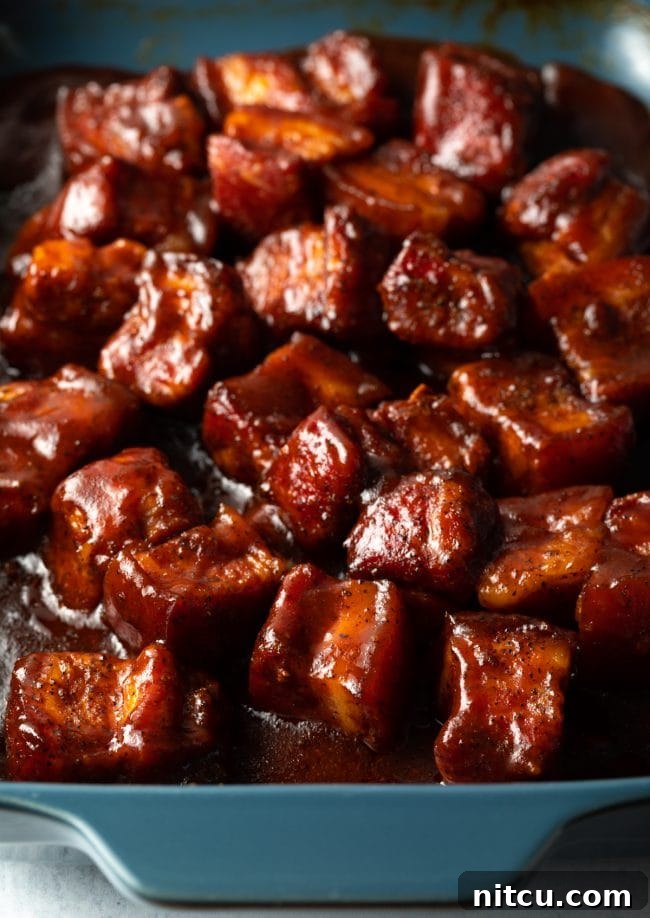 BBQ Pork Belly Candy Bites 10 A vibrant platter of smoked pork belly burnt ends served with Southern side dishes, ready for a feast.