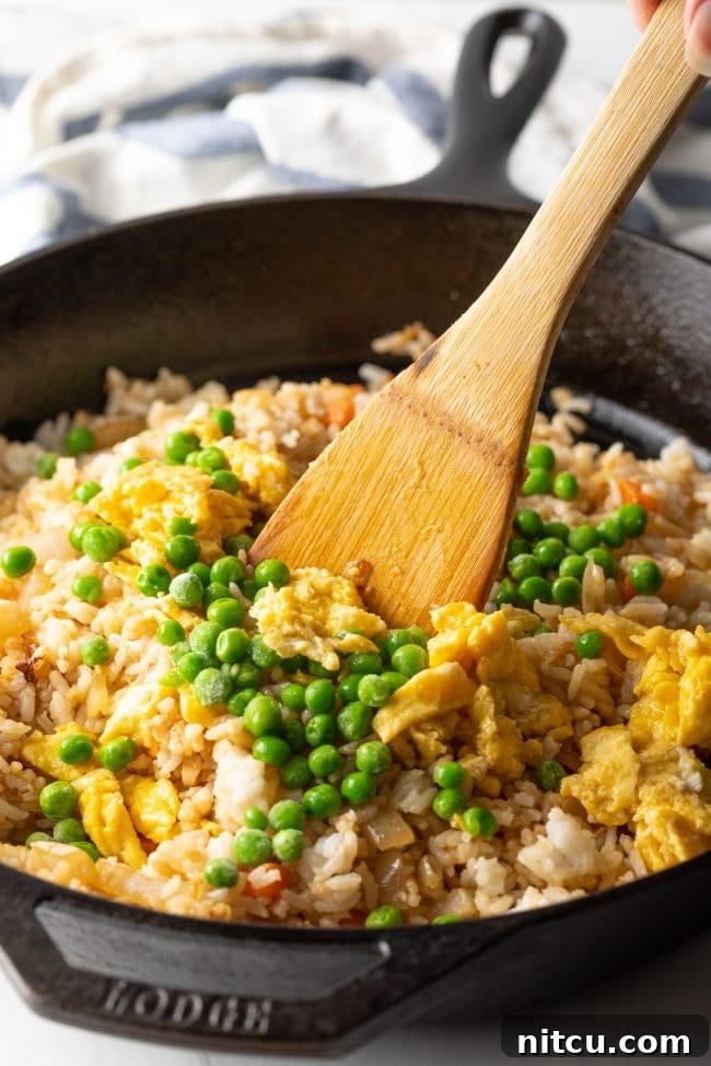 Perfect Homemade Hibachi Rice 11 A spatula combining fluffy rice and colorful veggies, ensuring even coating.