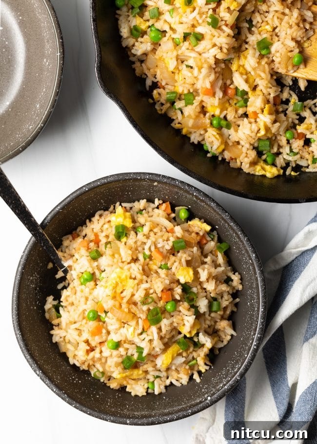 Perfect Homemade Hibachi Rice 13 Top down view bowl of Japanese fried rice next to skillet of food, highlighting a full meal spread.