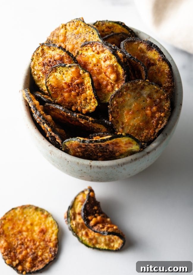 Crispy Air-Fried Zucchini Bites 10 Top down view of a rustic speckled bowl filled to the brim with air-fried zucchini chips, ready to be enjoyed.