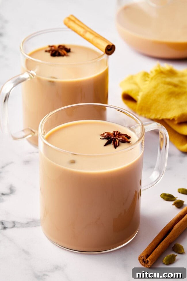 Finest Chai Tea Blends 10 Clear mugs filled with rich, frothy chai tea, ready to be savored for their aromatic warmth and comforting flavor.