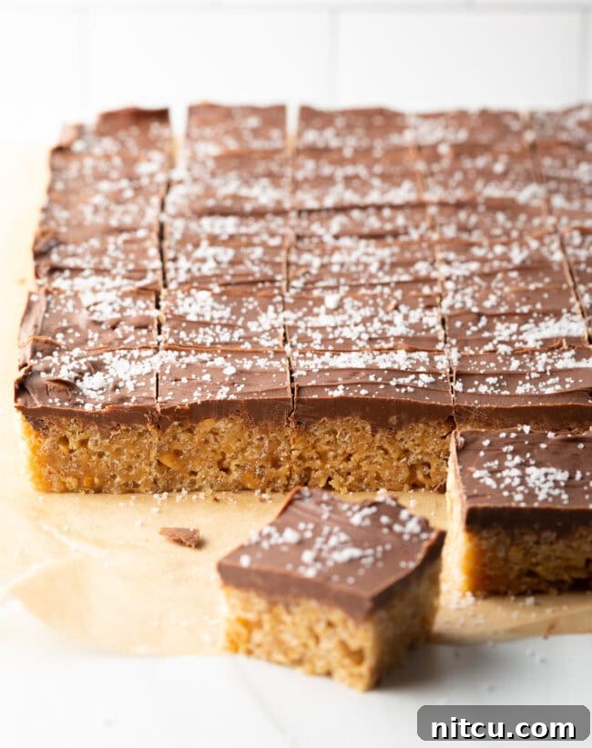 Peanut Butter Rice Krispie Treats 11 Scotcharoos cut into little squares on parchment paper.