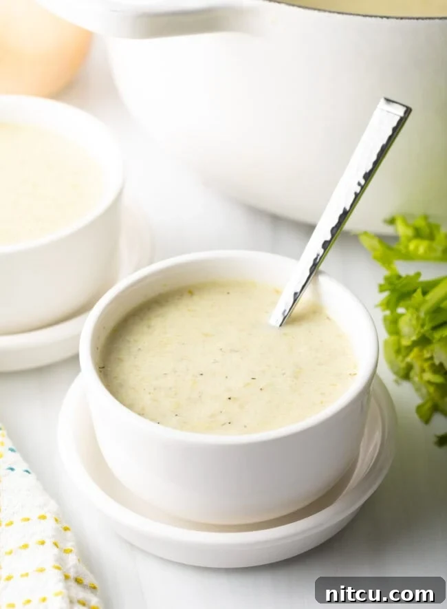 Bowl of celery soup with a metal spoon.