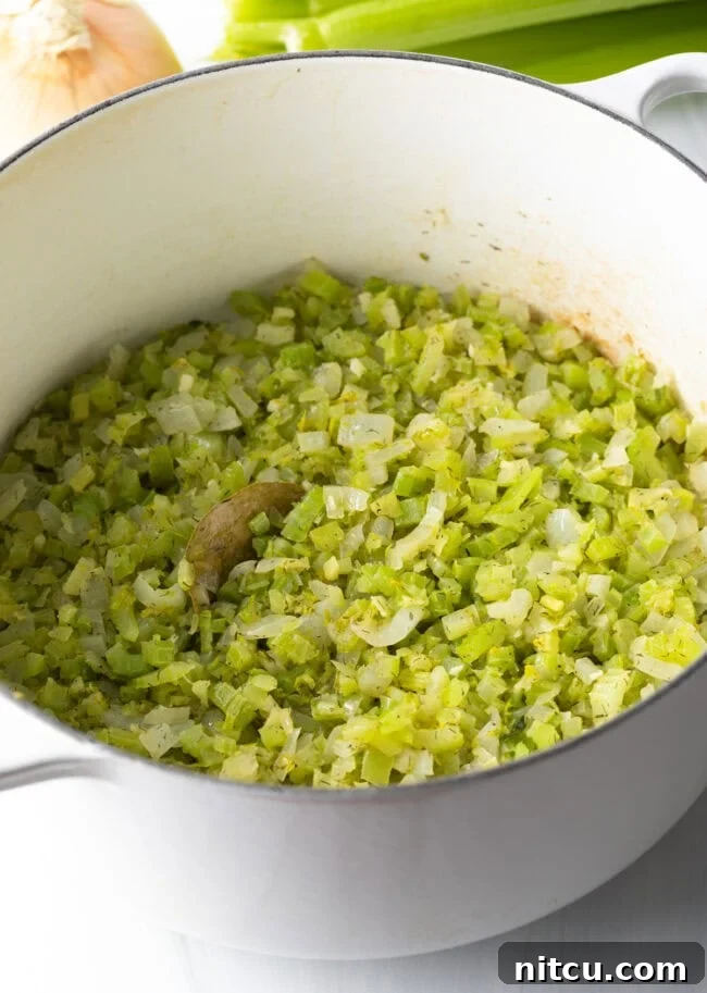 Chopped celery and onion cooking in a large pot.