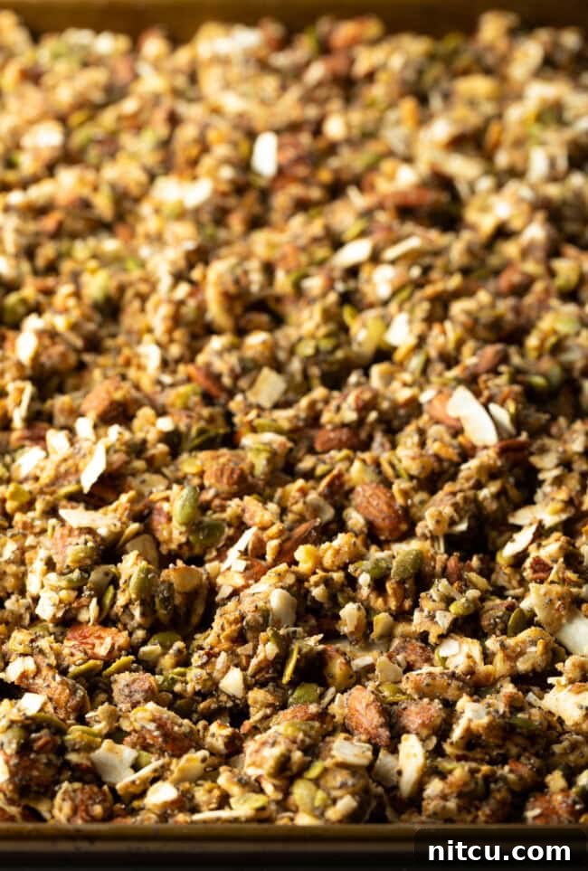 Ultimate Keto Granola 11 Baked keto granola on a baking sheet, golden and clumpy.