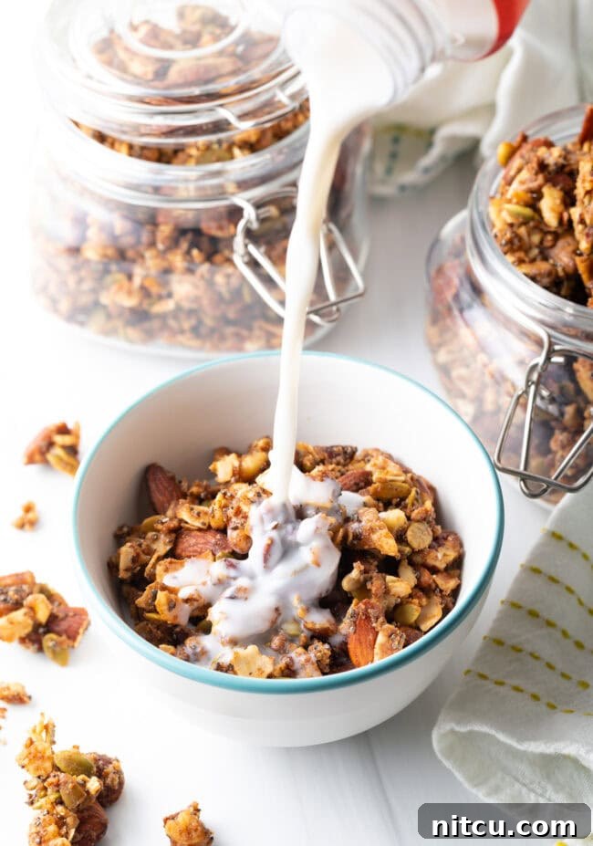Ultimate Keto Granola 15 Pouring milk from a jug into a bowl of keto nut granola, ready for breakfast.