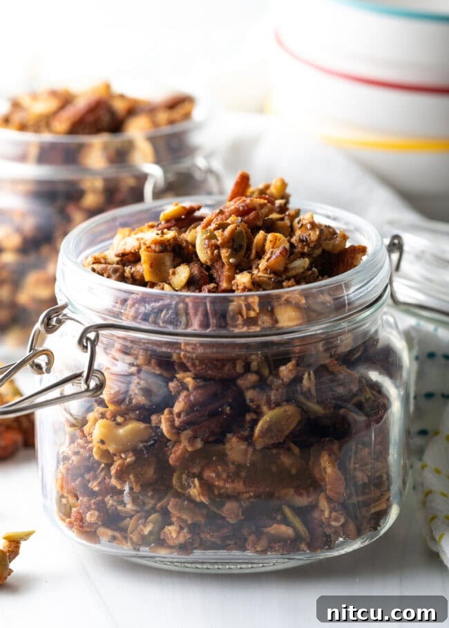 Ultimate Keto Granola 3 Close-up side view of a glass jar filled with golden, crunchy keto granola.