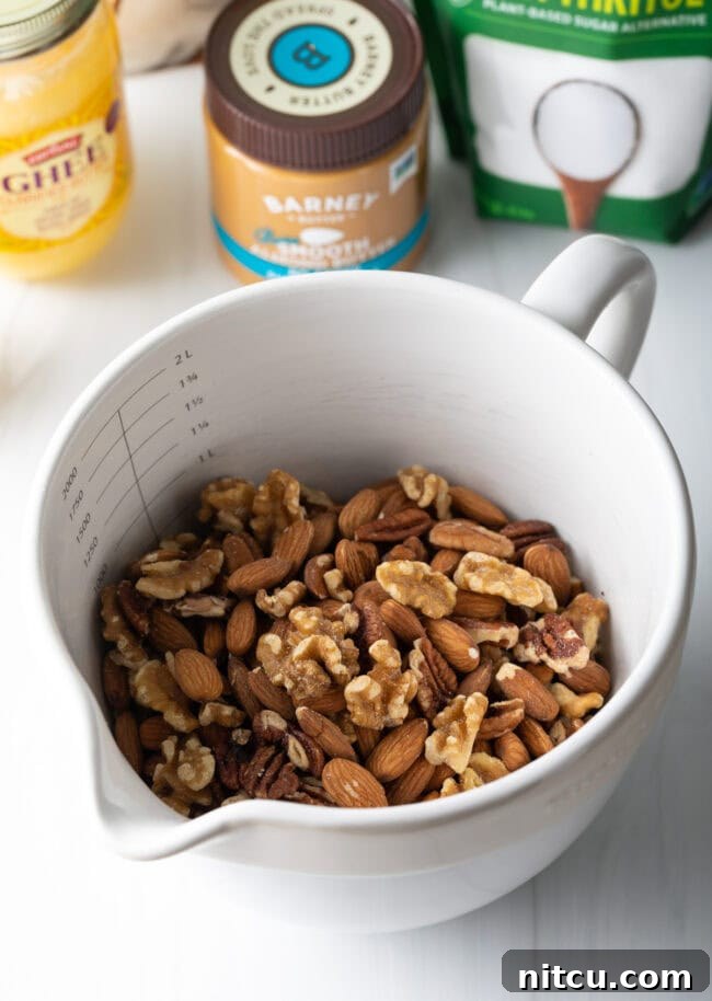 Ultimate Keto Granola 5 White mixing bowl with raw almonds, pecans, and walnuts, ready to be processed.