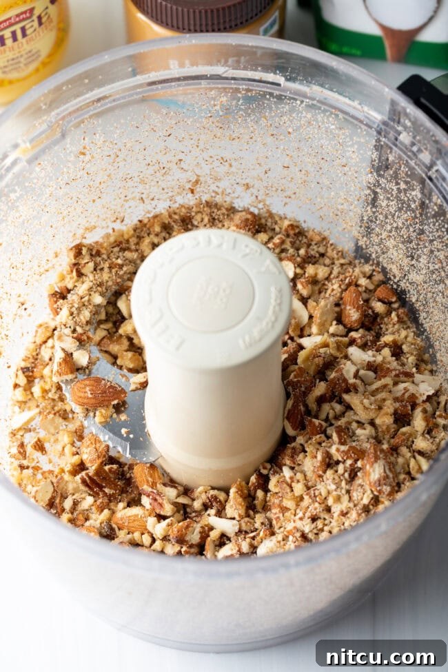 Ultimate Keto Granola 6 Close-up of mixed nuts and seeds in a large mixing bowl.