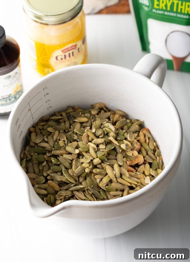 Ultimate Keto Granola 7 Various seeds and coconut chips being added to the nut mixture.