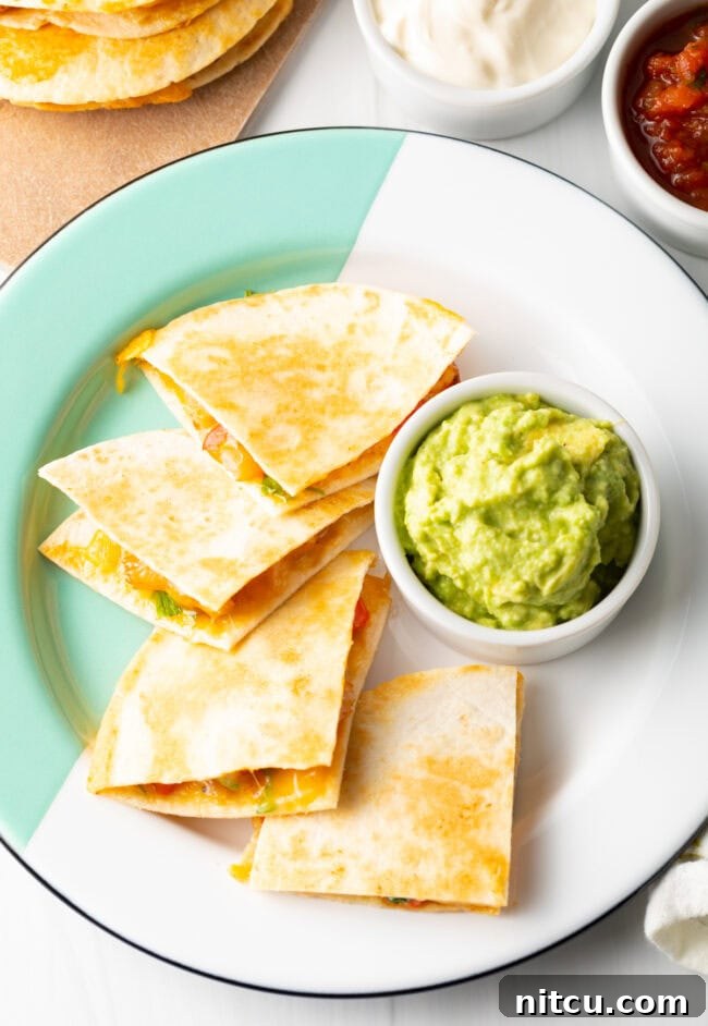 Effortless Shrimp Quesadilla Delight 3 Top down view four triangles of quesadilla on a plate with ramekin of guacamole.