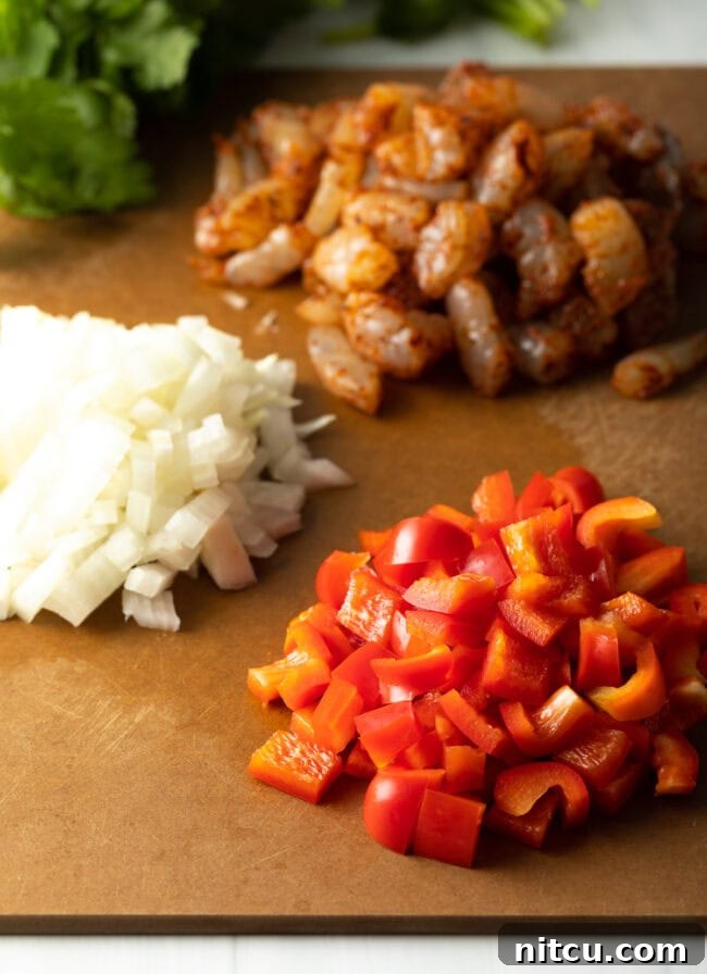 Effortless Shrimp Quesadilla Delight 4 Piles of chopped ingredients on a cutting board: shrimp, onion, red bell pepper.