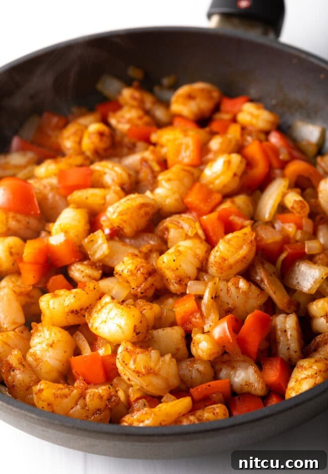 Effortless Shrimp Quesadilla Delight 6 Chopped onions, bell peppers and shrimp in the skillet.