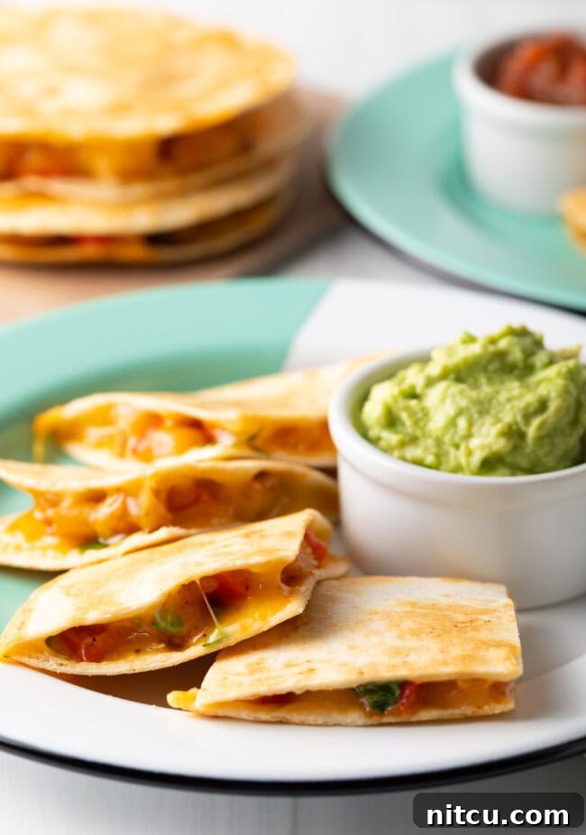Effortless Shrimp Quesadilla Delight 9 Shrimp quesadilla pieces on a plate with guacamole.