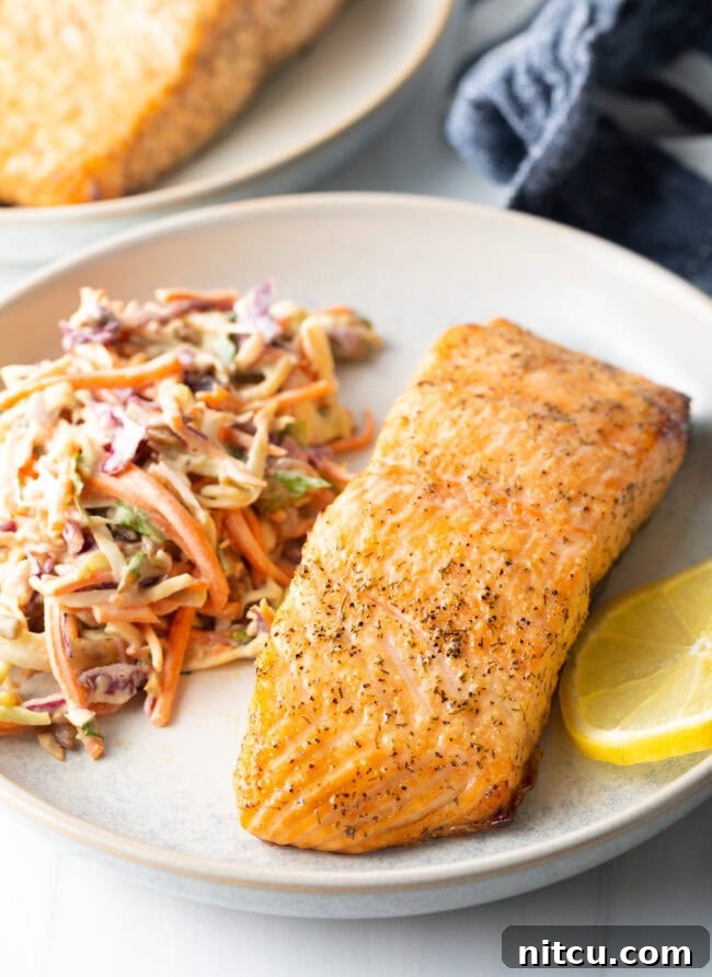 Crispy Skin Air Fryer Frozen Salmon 5 Plated fillet of salmon with coleslaw. Perfect air-fried salmon meal.