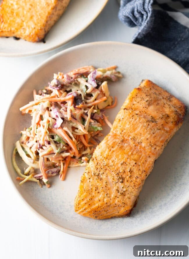 Crispy Skin Air Fryer Frozen Salmon 9 Top view salmon on a plate with coleslaw. Perfectly cooked air fryer salmon.