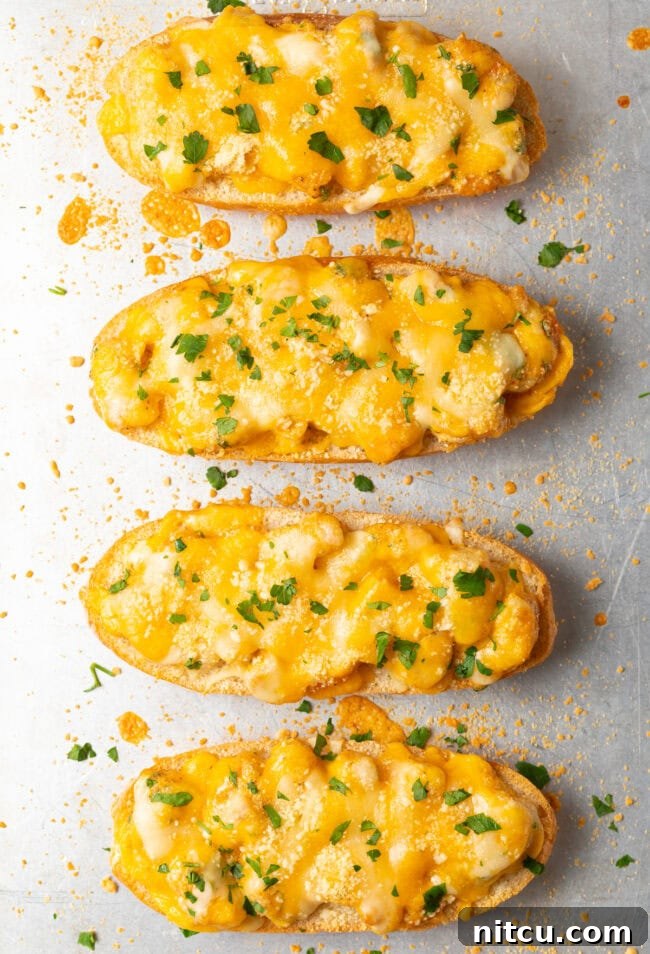 Cajun Shrimp Crostini 11 Top-down view of four perfectly baked, cheesy Cajun shrimp toast pieces, garnished with fresh herbs, ready for serving.