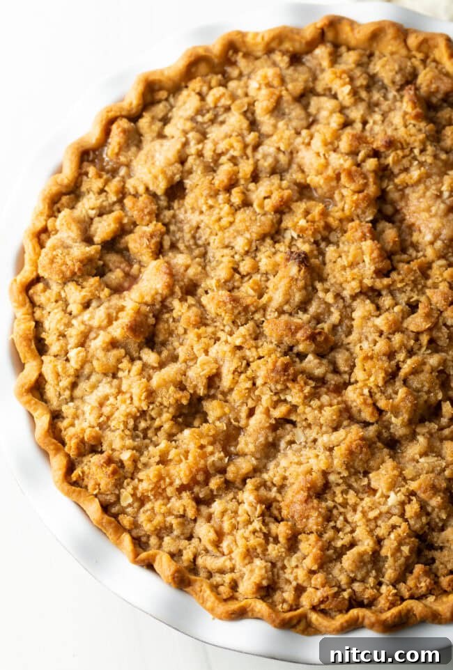 Anytime Peach Pie 13 Top view of a beautifully baked peach crumble pie, showing the golden-brown, crispy oat topping.