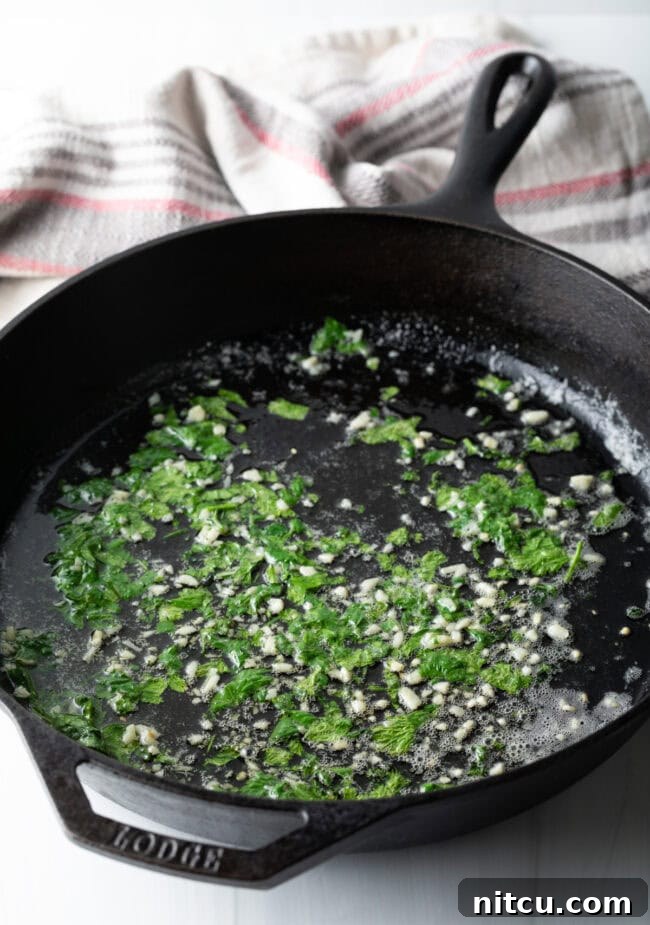 Cat iron skillet with garlic, butter, and cilantro.