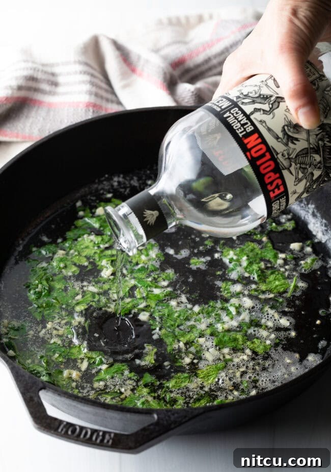 Pouring tequila into the cast iron skillet.