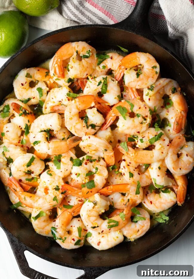 Top down view tequila lime sauteed shrimp in a skillet.