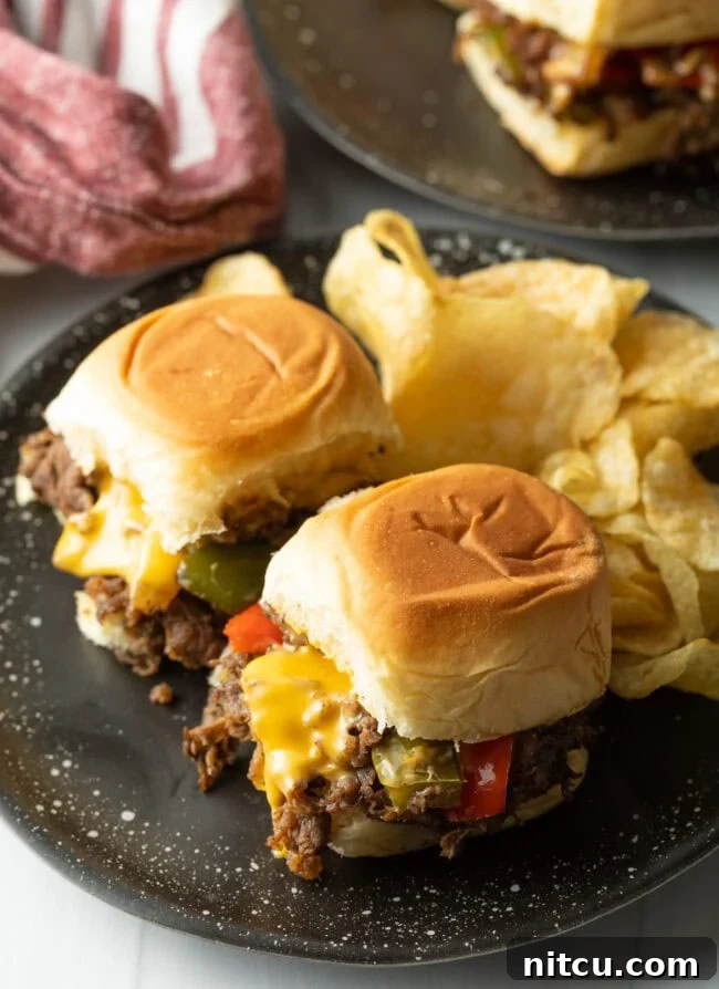 Philly Cheesesteak Bites 3 Top down two beef sliders on a plate with chips.