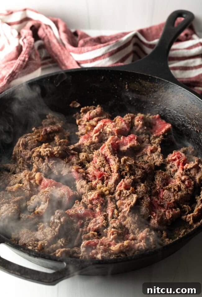 Philly Cheesesteak Bites 8 Cooking steak in a skillet.