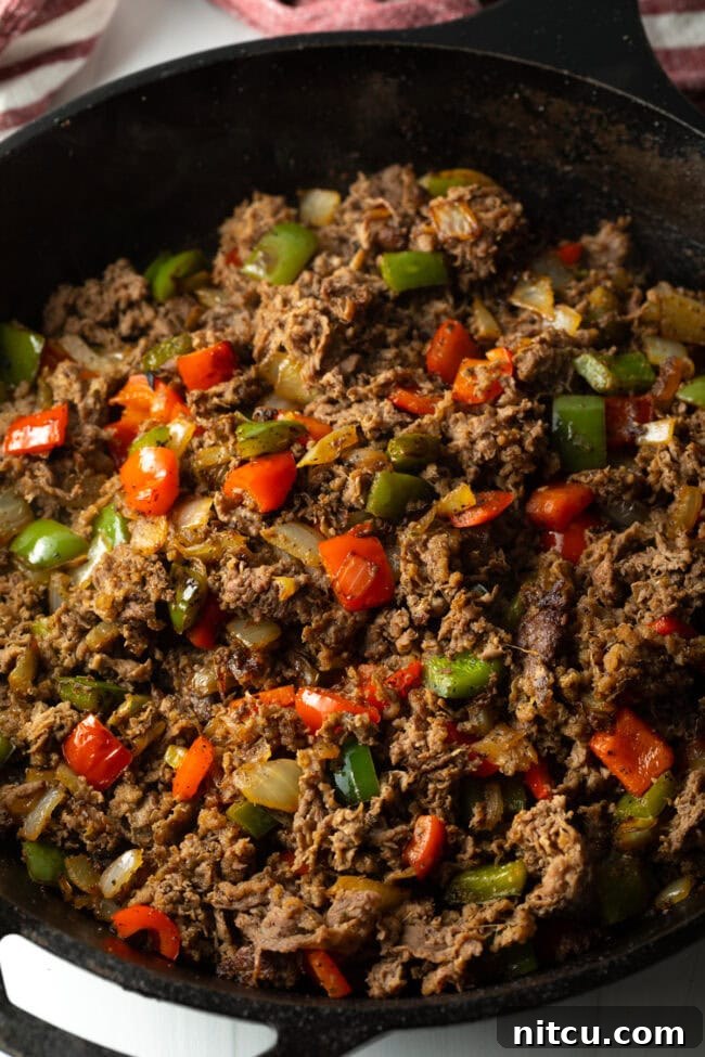 Philly Cheesesteak Bites 9 Cooked steak and peppers in a skillet.