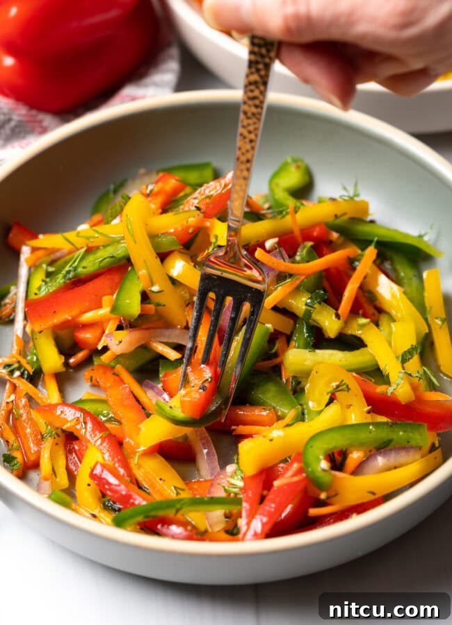 Roasted Pepper Medley 11 A fork taking a delicious bite of the bell pepper salad from a bowl, showcasing its freshness.