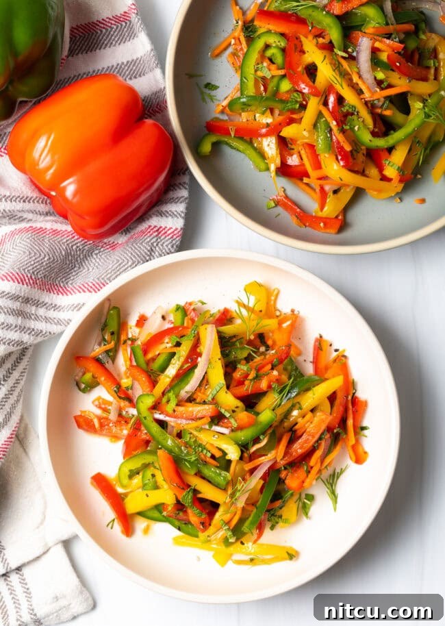 Roasted Pepper Medley 4 A top-down view of a vibrant summer bell pepper salad, generously served in a shallow white bowl, showcasing a mix of colorful peppers.