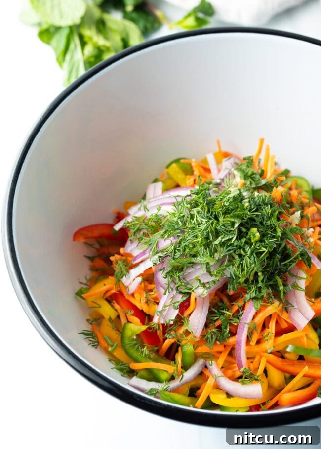 Roasted Pepper Medley 8 Freshly chopped dill and mint added to the bowl of sliced vegetables for the bell pepper salad, enhancing its aromatic appeal.