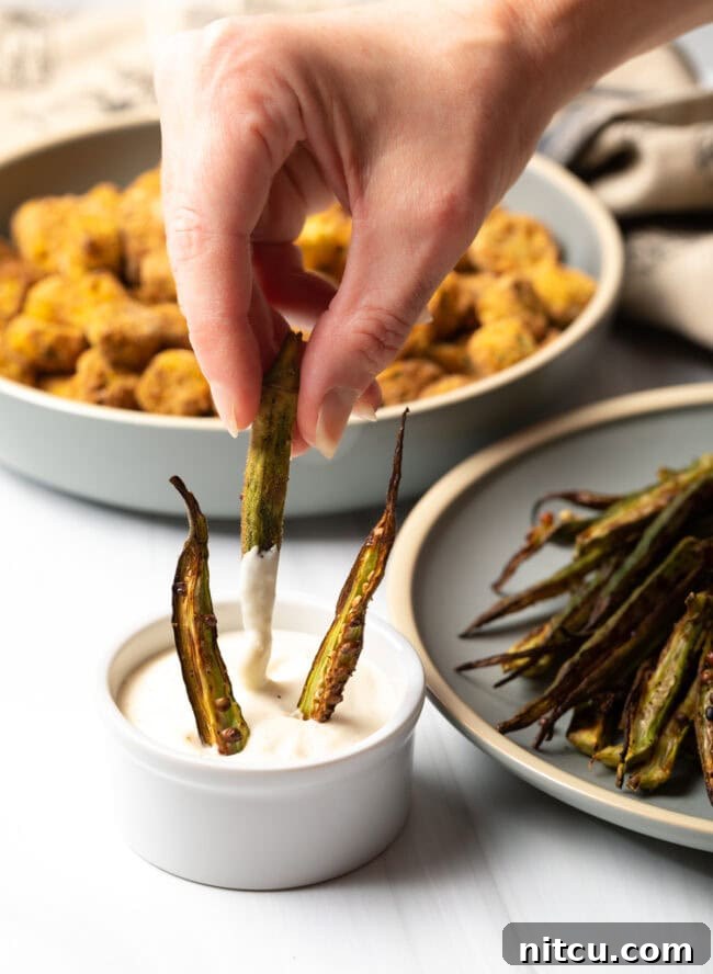 Crispy Air Fryer Okra Fries 18 Hand dipping okra fries into aioli.