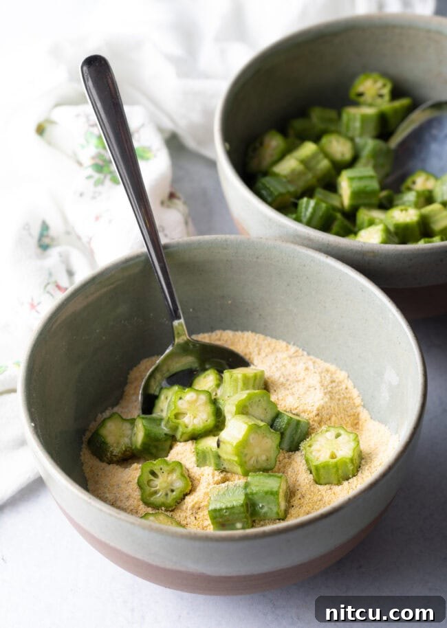Southern Fried Okra Bliss 8 Okra slices being added to a bowl with cornmeal breading mixture, ensuring full coverage.