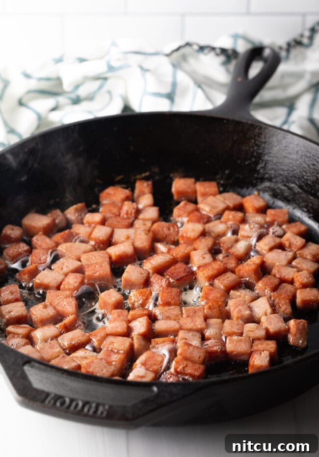 Tropical Kimchi Fried Rice 5 Frying cubes of spam in a cast iron skillet.
